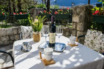 a table with a bottle of wine and glasses on it at Apartment Marko in Kotor