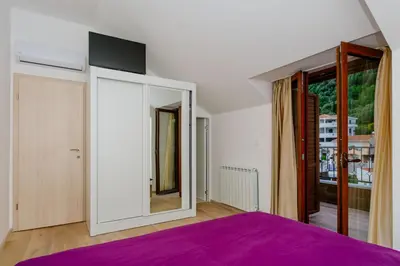 a bedroom with a purple bed and a large mirror at Opium Mar Apartments in Petrovac na Moru