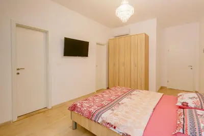 a bedroom with a bed and a tv on the wall at Opium Mar Apartments in Petrovac na Moru