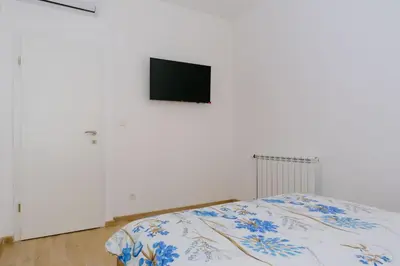 a bedroom with a bed and a tv on a wall at Opium Mar Apartments in Petrovac na Moru