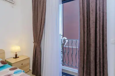 a bedroom with a bed and a window with curtains at Opium Mar Apartments in Petrovac na Moru