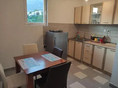 a kitchen with a wooden table and a refrigerator at Stan Daria in Sutomore