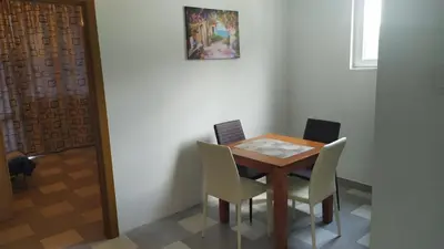 a dining room table with chairs and a picture on the wall at Stan Daria in Sutomore