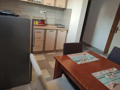 a small kitchen with a table and a refrigerator at Stan Daria in Sutomore