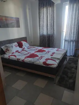 a bedroom with a bed with a red and white blanket at Stan Daria in Sutomore