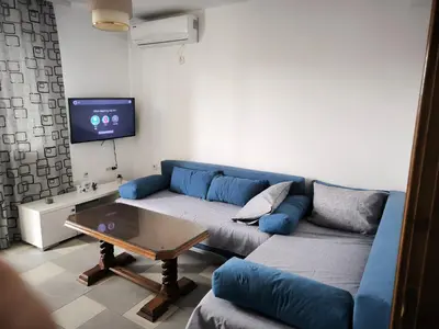 a living room with a blue couch and a table at Stan Daria in Sutomore