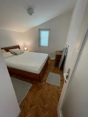a small bedroom with a bed and a window at Nikola's apartment in Budva