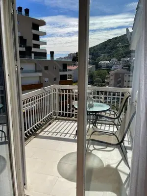 a balcony with a table and chairs on a balcony at Nikola's apartment in Budva