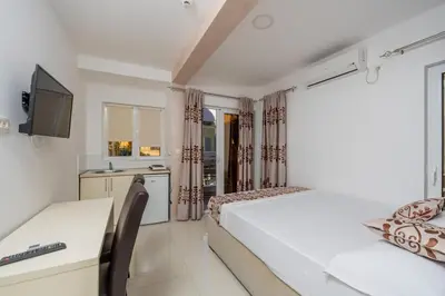 a bedroom with two beds and a desk and a tv at Ponte di Ferro in Budva