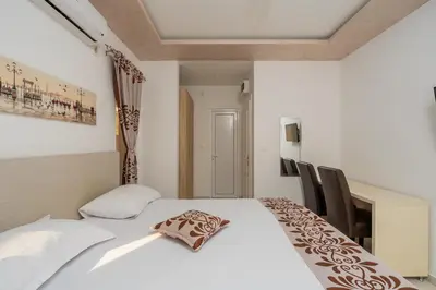 a bedroom with a white bed with a pillow on it at Ponte di Ferro in Budva