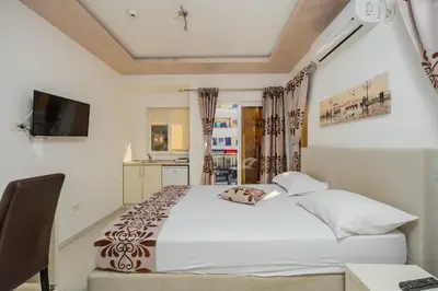 a bedroom with a white bed and a television at Ponte di Ferro in Budva