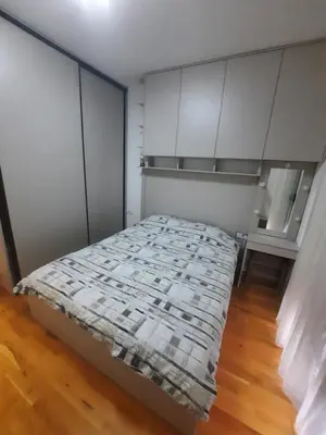 a bed in a room with white cabinets at Podgorica Zabjelo titex 3 in Podgorica
