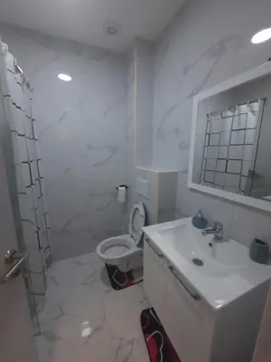 a white bathroom with a toilet and a sink at Podgorica Zabjelo titex 3 in Podgorica