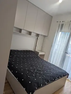 a bed in a room with white cabinets at Podgorica Zabjelo titex 3 in Podgorica