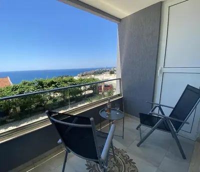 a balcony with two chairs and a table and a view of the ocean at Ferienwohnung - Devas in Ulcinj