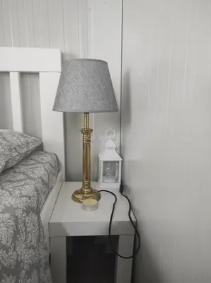 a lamp on a table next to a bed at Apartman sa sopstvenim dvoristem , pored mora in Bigovo