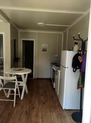 a kitchen with a white refrigerator and a table at Apartman sa sopstvenim dvoristem , pored mora in Bigovo