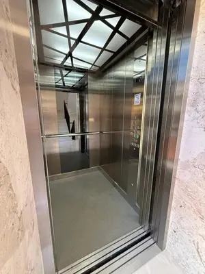 a glass elevator in a building with a staircase at Apart Hotel Spa Resort Becici, Budva Апартаменты с двумя мастер-спальнями in Becici