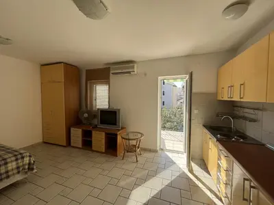 a kitchen with a sink and a tv in a room at Perfect studio-apartment in Petrovac in Petrovac na Moru