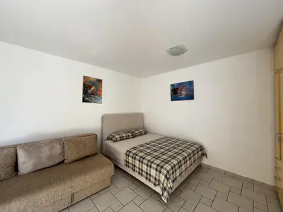 a living room with a couch and a bed at Perfect studio-apartment in Petrovac in Petrovac na Moru