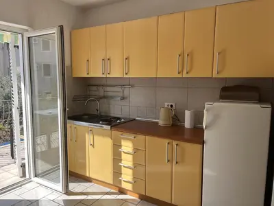 a kitchen with yellow cabinets and a white refrigerator at Perfect studio-apartment in Petrovac in Petrovac na Moru