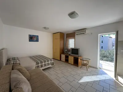 a living room with a bed and a television at Perfect studio-apartment in Petrovac in Petrovac na Moru