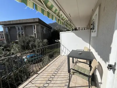 a balcony with a wooden table and a table at Perfect studio-apartment in Petrovac in Petrovac na Moru