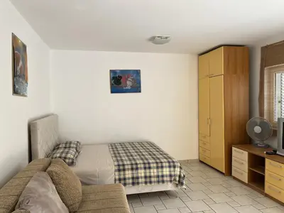a bedroom with a bed and a couch at Perfect studio-apartment in Petrovac in Petrovac na Moru