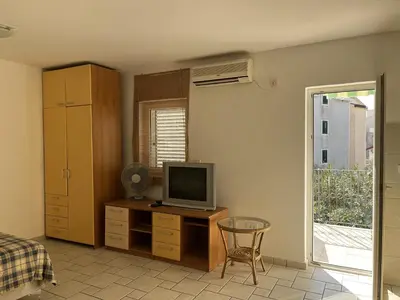a bedroom with a desk with a television on it at Perfect studio-apartment in Petrovac in Petrovac na Moru