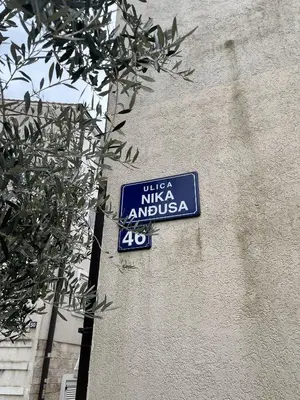 a blue street sign on the side of a building at Perfect studio-apartment in Petrovac in Petrovac na Moru
