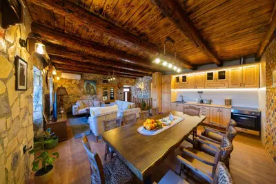 a kitchen and living room with a table and chairs at Village Villa Dobrski Dvori in Cetinje
