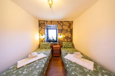 a small room with two beds and a window at Village Villa Dobrski Dvori in Cetinje