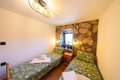 a room with two beds and a stone wall at Village Villa Dobrski Dvori in Cetinje