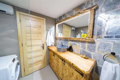 a bathroom with a sink and a stone wall at Village Villa Dobrski Dvori in Cetinje
