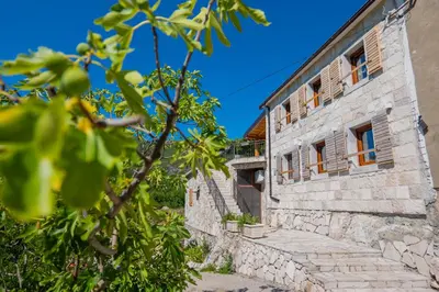 an old stone house with a stone staircase outside at Village Villa Dobrski Dvori in Cetinje
