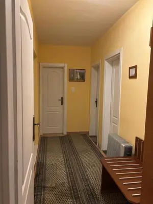 a hallway with yellow walls and a door and a rug at Galicia Hills in Becici