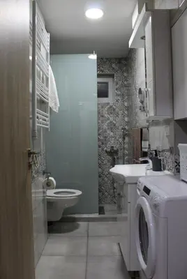 a bathroom with a toilet sink and a washing machine at Moraca River Residence in Podgorica