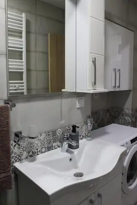 a bathroom with a sink and a washing machine at Moraca River Residence in Podgorica