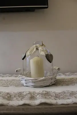 a candle in a glass jar on a table at Moraca River Residence in Podgorica