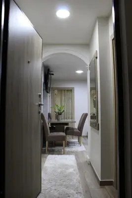 a hallway with a dining room with a table and chairs at Moraca River Residence in Podgorica