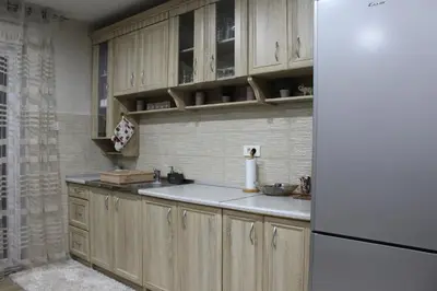 a kitchen with wooden cabinets and a white refrigerator at Moraca River Residence in Podgorica