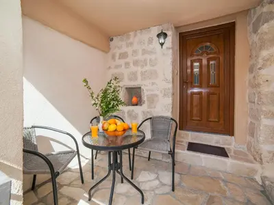 a table and chairs with oranges on it in a hallway at Apartments Ana in Kotor