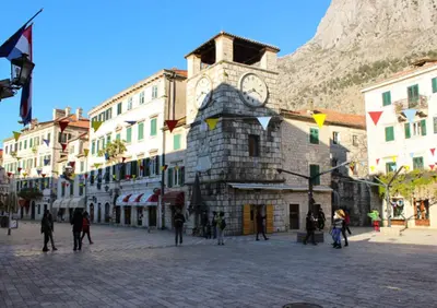 a building with a clock tower in the middle of a street at Apartments Ana in Kotor