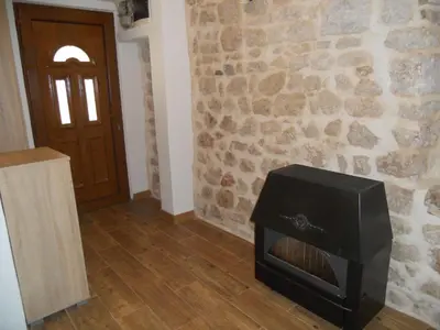 a fireplace in a room with a stone wall at Apartments Ana in Kotor