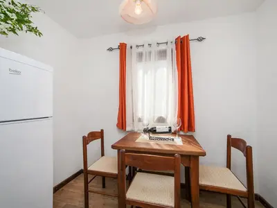 a kitchen with a table and chairs and a refrigerator at Apartments Ana in Kotor