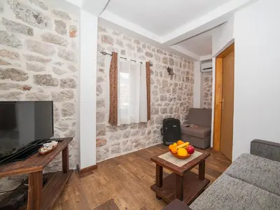 a living room with a stone wall at Apartments Ana in Kotor
