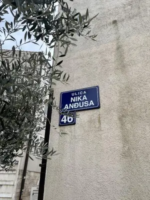 a blue street sign on the side of a building at Perfect spot Petrovac in Petrovac na Moru