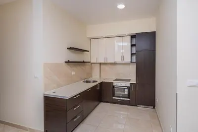 a kitchen with white walls and brown cabinets at Deluxe Apartments Shine in Becici