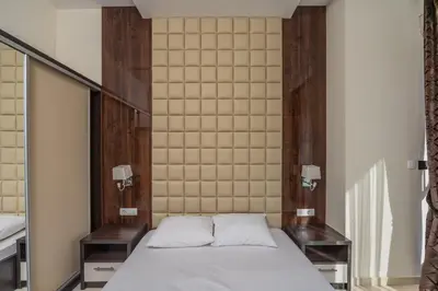 a bed in a room with two tables and a mirror at Deluxe Apartments Shine in Becici