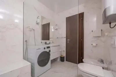 a white bathroom with a sink and a washing machine at Deluxe Apartments Shine in Becici
